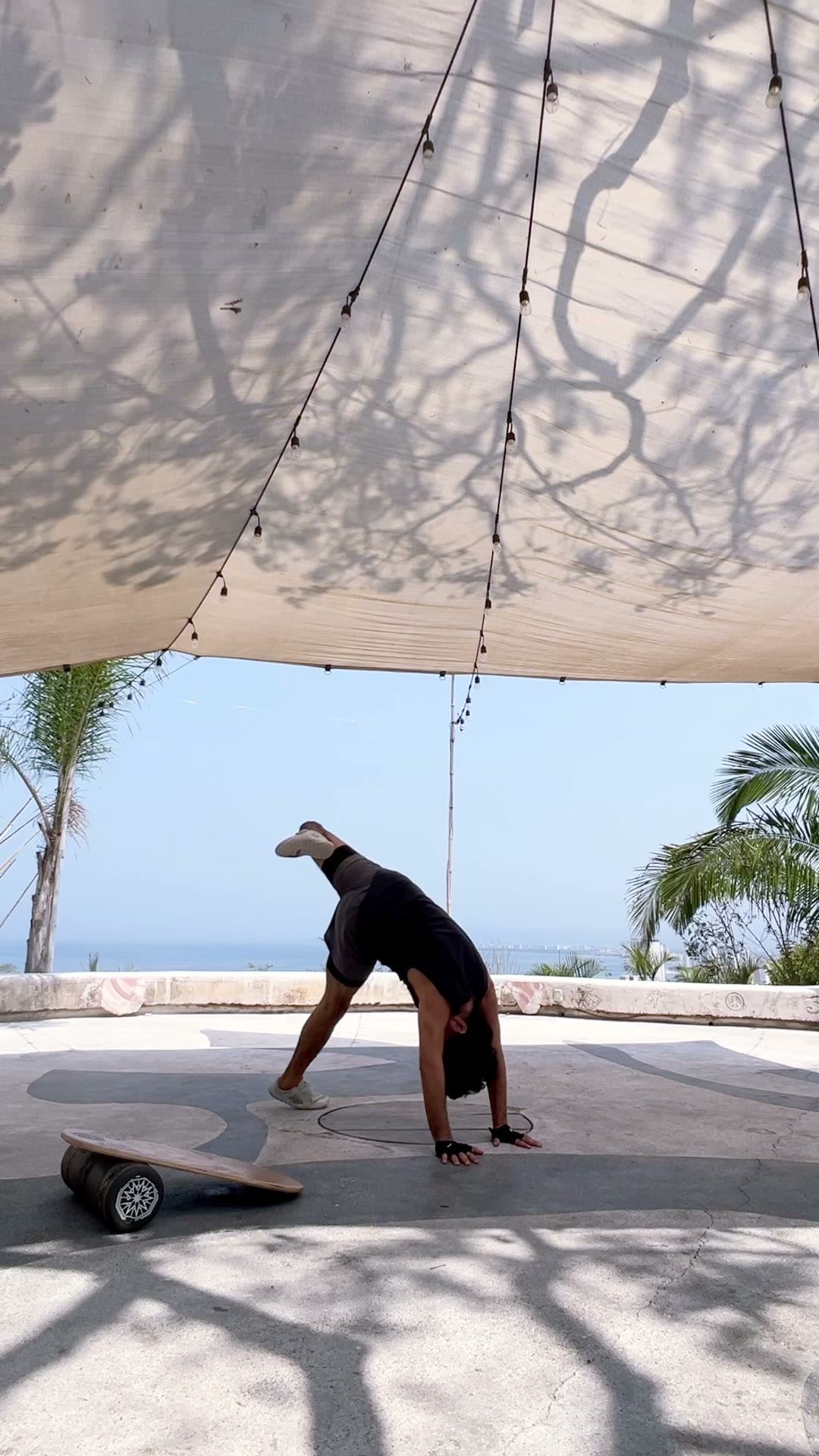 Movement practice under a shade sail facing the ocean